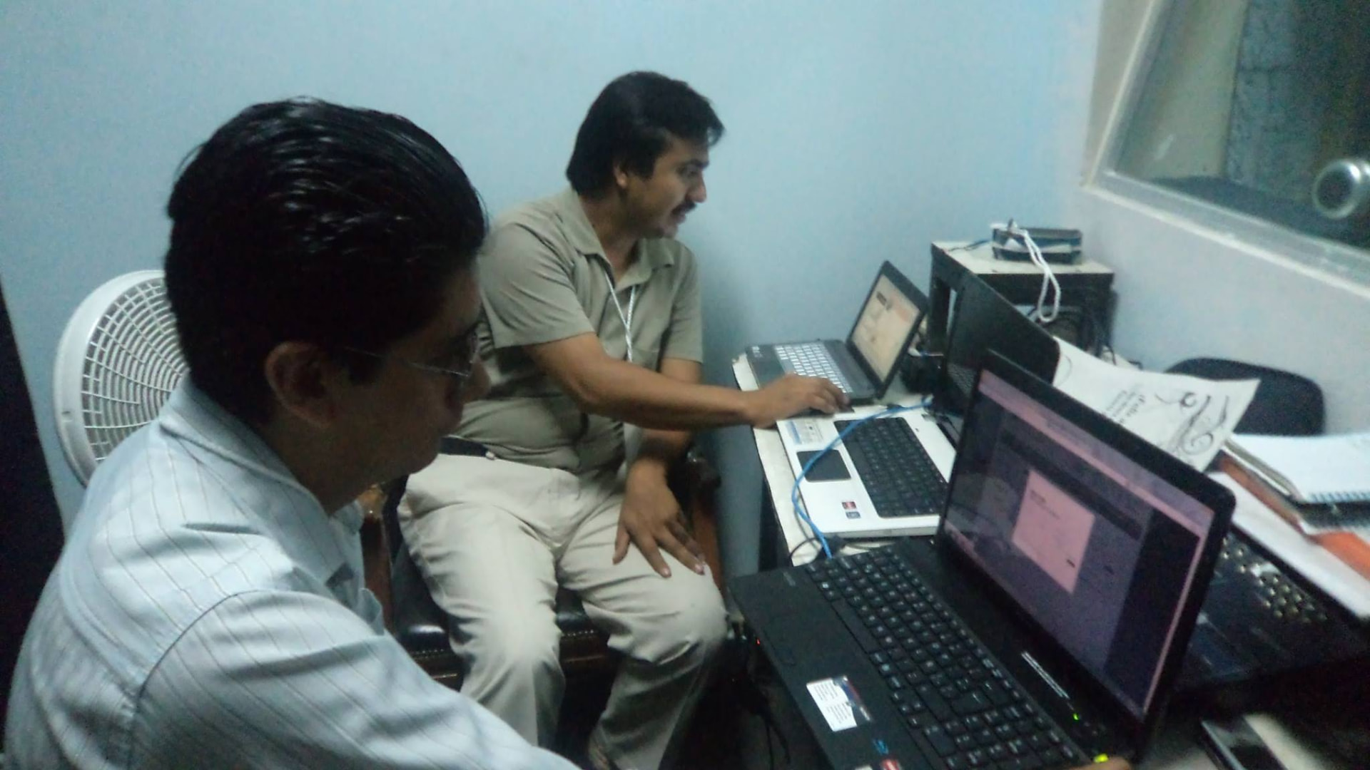 Integrantes del equipo monitoreando la señal en laptops junto a la mezcladora